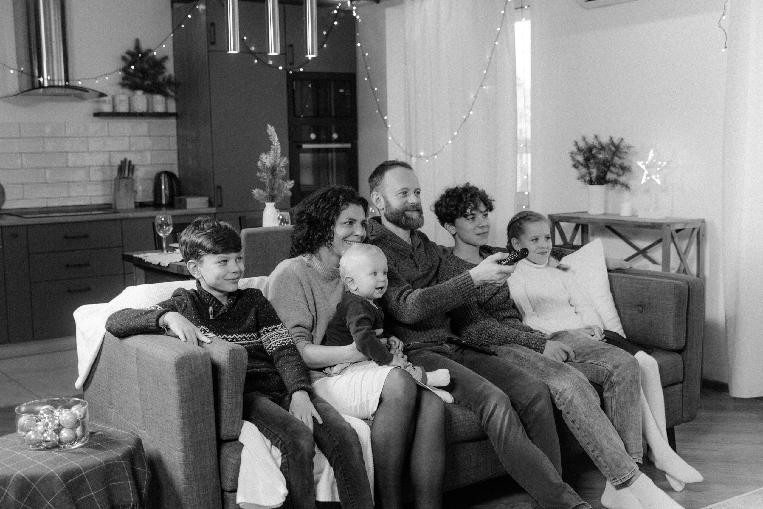 Famille regardant une série dans un salon connecté avec télévision moderne
